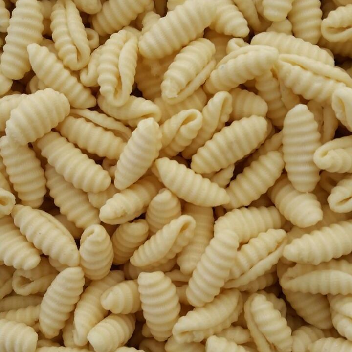 Frisch geformte Gnocchetti Sardi, die zum Trocknen ausgelegt sind. Die kleinen, muschelförmigen Nudeln liegen dicht an dicht.